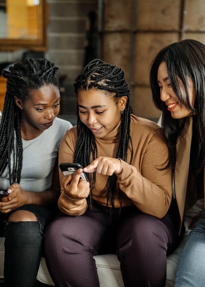 Several classmates sit down looking at iPhone