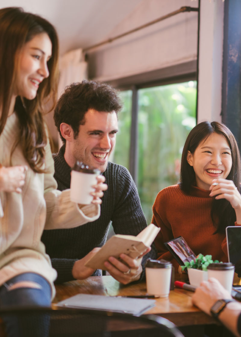 Several students enjoy coffee and company around a table